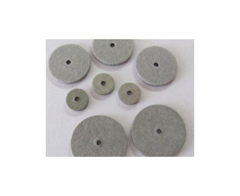 May include: A set of eight gray felt polishing wheels of various sizes. The wheels have a central hole for attachment to a polishing tool.