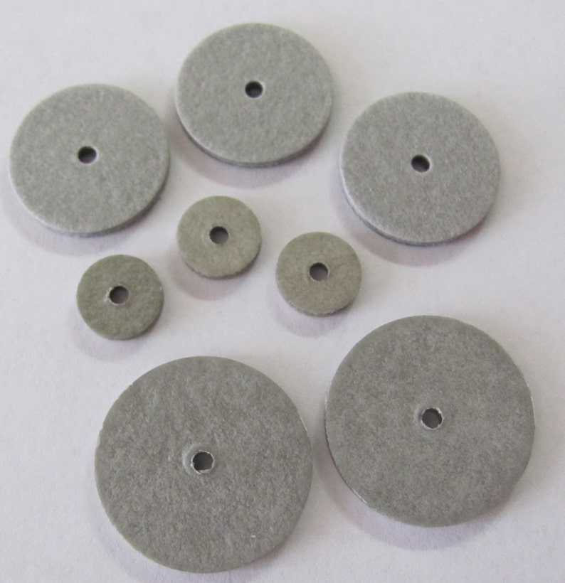 May include: Assortment of gray felt sanding discs of various sizes with a hole in the center.