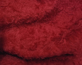 May include: Close-up of a deep red fuzzy fabric with a soft, plush texture.