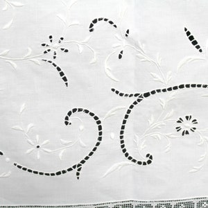 May include: White cotton fabric with a delicate embroidered design of black vines and flowers. The embroidery is done in a cutwork style, with the fabric removed to create the design.