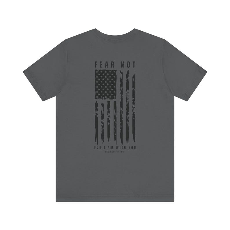 K&ouml;nnte beinhalten: Ein anthrazitfarbenes T-Shirt mit einem abgenutzten amerikanischen Flaggen-Design und dem Text "FEAR NOT FOR I AM WITH YOU, ISAIAH 41:10".