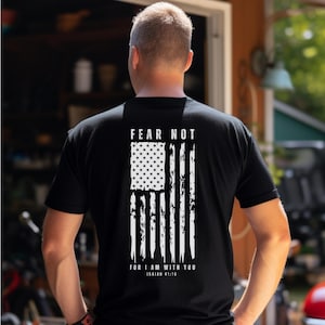K&ouml;nnte beinhalten: Schwarzes T-Shirt mit einem wei&szlig;en, abgenutzten Design einer amerikanischen Flagge und dem Text "F&uuml;rchte dich nicht, denn ich bin bei dir, Jesaja 41:10".
