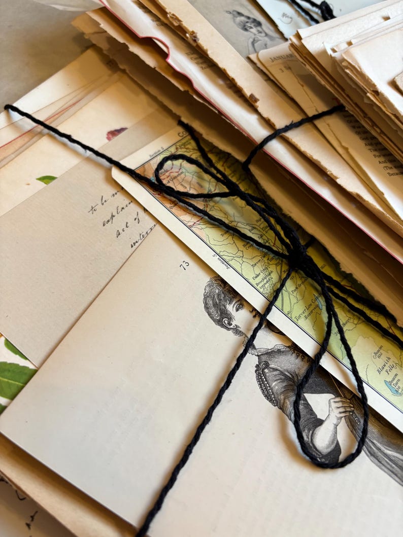 Bundle of over 100 vintage and antique paper ephemera pieces, including aged letters, postcards, and documents, arranged in a flat lay on a rustic wooden surface