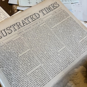 Bundle of over 100 vintage and antique paper ephemera pieces, including aged letters, postcards, and documents, arranged in a flat lay on a rustic wooden surface ready for scrapbooking and paper craft projects