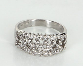 Op de afbeelding: Een zilveren ring met een delicaat ontwerp van kleine diamanten die in een band zijn gezet.