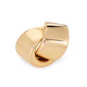 May include: A gold-colored ring with a unique, intertwined design. The ring features a smooth, polished surface and a bold, geometric shape. The ring's design is a continuous loop, creating a modern and stylish look.