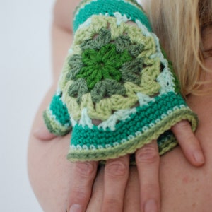 Puede incluir: Guantes sin dedos de ganchillo verde y blanco con un patrón floral.