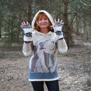 May include: A white hooded sweatshirt with a brown and white polar bear design. The sweatshirt has a brown and white patchwork design on the sleeves and a white hood.