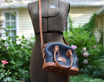 Bolso bandolera tipo boliche Dooney & Bourke AWL Norfolk de piel negra y canela