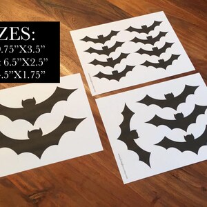 Op de afbeelding: Zwarte vleermuisstickers in drie maten: groot (24.77cm x 8.89cm), medium (16.51cm x 6.35cm) en klein (11.43cm x 4.45cm). De stickers liggen op wit papier, meerdere vellen zijn zichtbaar. De tekst "3 MATEN:" staat bovenaan.