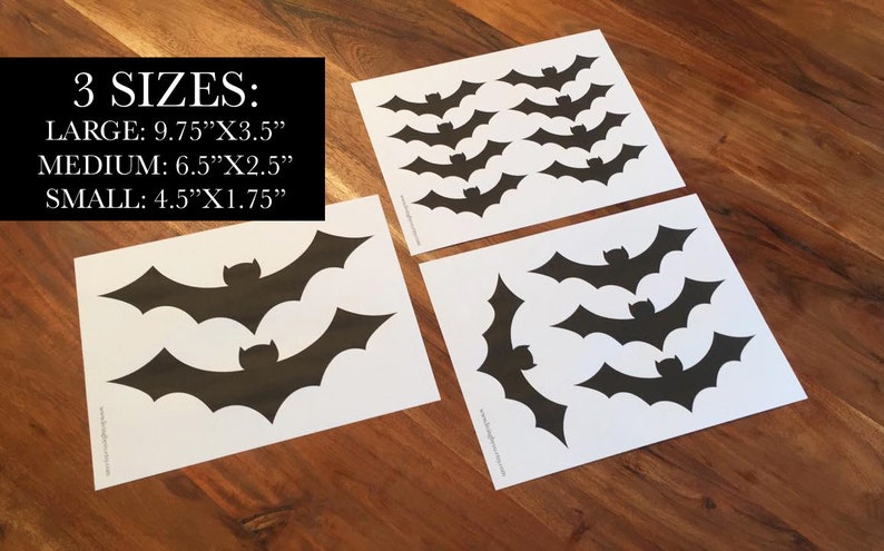 Op de afbeelding: Zwarte vleermuisstickers in drie maten: groot (24.77cm x 8.89cm), medium (16.51cm x 6.35cm) en klein (11.43cm x 4.45cm). De stickers liggen op wit papier, meerdere vellen zijn zichtbaar. De tekst "3 MATEN:" staat bovenaan.