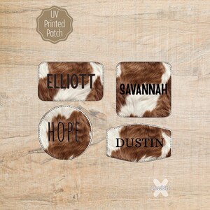 May include: Four UV printed patches with a cowhide pattern. Each patch has a different shape and features a name in black: "ELLIOTT", "SAVANNAH", "HOPE", and "DUSTIN". The patches are on a wooden surface.