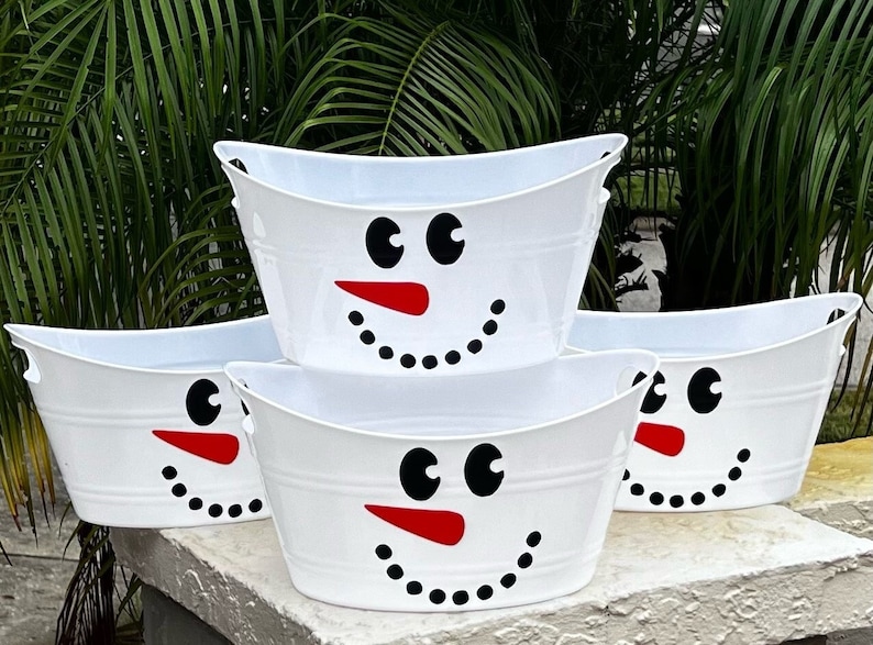 personalized christmas gift basket snowman bucket best seller trending christmas decor Snowman Face Holiday Basket Christmas Gift Basket Porch Decor Guest Bathroom Basket Holiday Tote Snowman Favor Bucket Personalized Basket May include: Three white metal tubs with snowman faces. The snowman faces have black eyes, red noses, and black dots for a mouth.
