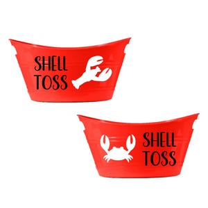 May include: Two red metal buckets with the words "SHELL TOSS" in black. One bucket has a white lobster graphic, and the other has a white crab graphic. The buckets have a curved top edge.