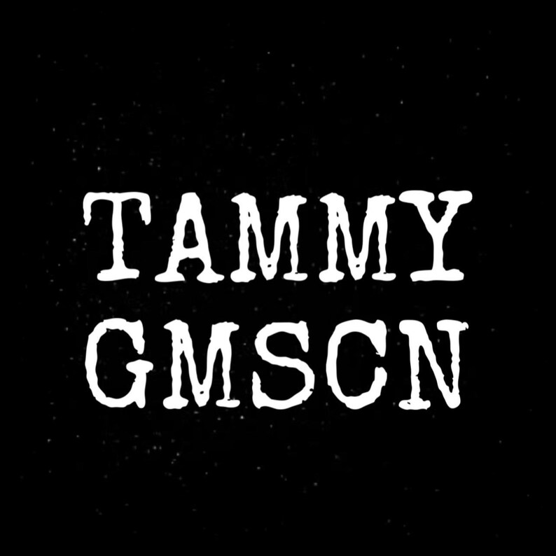 May include: White text on a black background reads "TAMMY GMSCN" in a bold, slightly distressed font. The text is centered, and the background has a subtle speckled effect.
