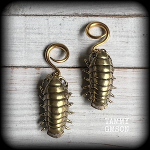 May include: A set of three ceramic mugs with a speckled, matte finish. The mugs are in shades of cream, light gray, and dark gray. Each mug has a simple, minimalist design and a rounded handle.