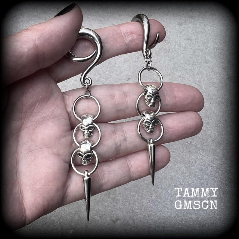 These awesome gauged earrings feature punk metal skull and spike dangles, are nice and lightweight, weighing 10 grams a piece, and nice and dangly at 10 cms from tip to tip.
This pair has been made on 2 gauge (6mm) surgical steel full curl hooks