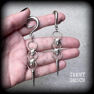 These awesome gauged earrings feature punk metal skull and spike dangles, are nice and lightweight, weighing 10 grams a piece, and nice and dangly at 10 cms from tip to tip.
This pair has been made on 2 gauge (6mm) surgical steel full curl hooks