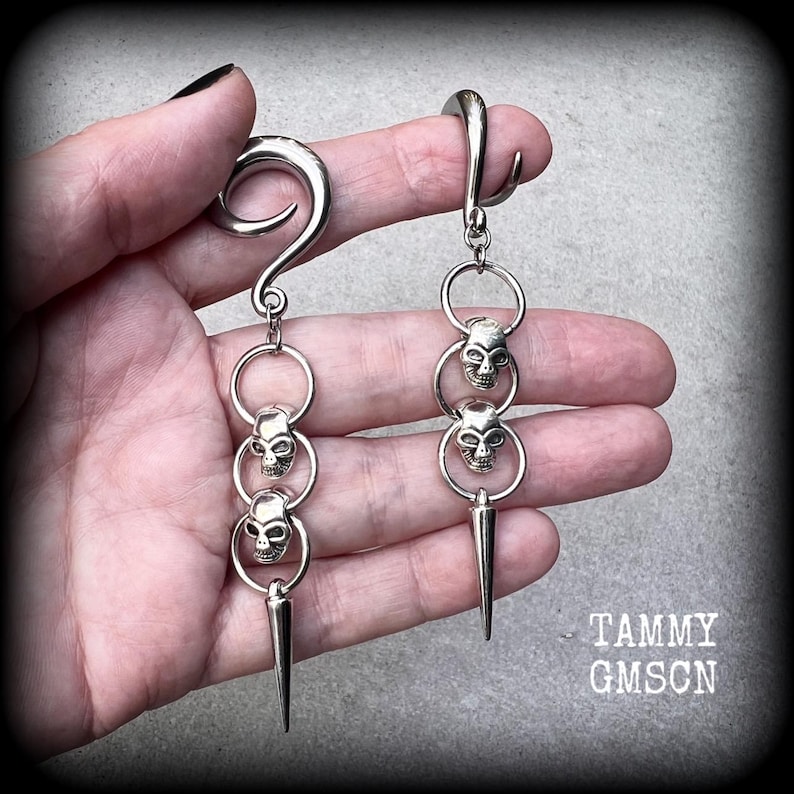 These awesome gauged earrings feature punk metal skull and spike dangles, are nice and lightweight, weighing 10 grams a piece, and nice and dangly at 10 cms from tip to tip.
This pair has been made on 2 gauge (6mm) surgical steel full curl hooks