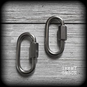 May include: Two silver-toned metal oval quick links, each featuring a threaded hexagonal locking nut on one side. The hardware components are smooth and metallic, designed for secure connection, with the text TAMMY GMSCN visible in the corner.