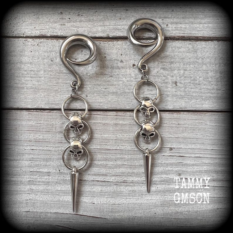 These awesome gauged earrings feature punk metal skull and spike dangles, are nice and lightweight, weighing 10 grams a piece, and nice and dangly at 10 cms from tip to tip.
This pair has been made on 2 gauge (6mm) surgical steel full curl hooks