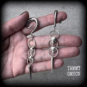 These awesome gauged earrings feature punk metal skull and spike dangles, are nice and lightweight, weighing 10 grams a piece, and nice and dangly at 10 cms from tip to tip.
This pair has been made on 2 gauge (6mm) surgical steel full curl hooks