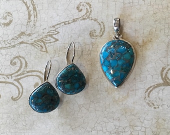 May include: A set of turquoise earrings and a pendant necklace. The turquoise stones are a mottled blue and green color and are set in silver.
