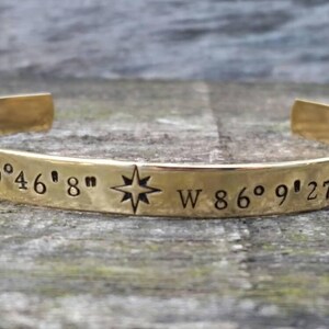 May include: Gold bracelet with a compass star and engraved coordinates: N 39° 46' 8" W 86° 9' 27"