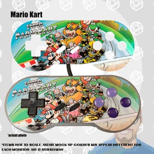 May include: Two Super Mario Kart-themed game controllers. The controllers feature a colorful design with Mario, Luigi, Princess Peach, and other characters racing on a track. The text "Mario Kart" and "Super Mario Kart" are visible.