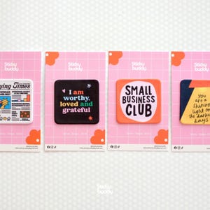 May include: Four colorful stickers on pink cards. The stickers have text that reads "I am worthy, loved and grateful", "Small Business Club", and "You are a shining light on the darker days". The stickers are from Sticky Buddy.