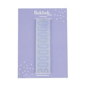 Puede incluir: Una tarjeta de color lila claro con un molde transparente en forma de óvalo para arte de resina. El molde es vertical y tiene múltiples cavidades ovaladas. La tarjeta tiene el texto "Bebek makes" y "UV Resin Cures In 2-4 Minutes".