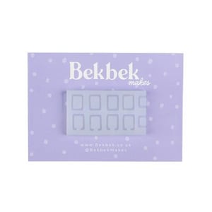 Puede incluir: Un molde de silicona azul claro con diez formas rectangulares, cada una con una abertura curva. El molde está sobre una tarjeta lila claro con lunares blancos. El texto "Bekbek makes" está en la parte superior y la información del sitio web en la inferior.