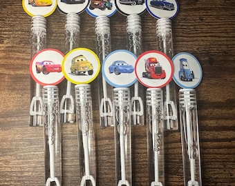 May include: Set of ten clear plastic bubble wands with colorful character stickers featuring Cars characters like Lightning McQueen, Mater, and others. The stickers are round and feature a white border.