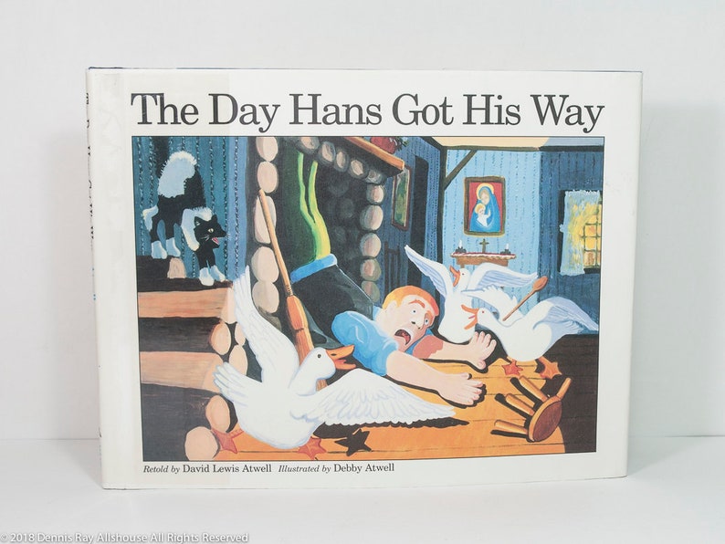 May include: A children's book titled "The Day Hans Got His Way" with a colorful illustration. The cover art depicts a chaotic scene with a frightened boy, geese, and a skunk. The book is retold by David Lewis Atwell and illustrated by Debby Atwell.