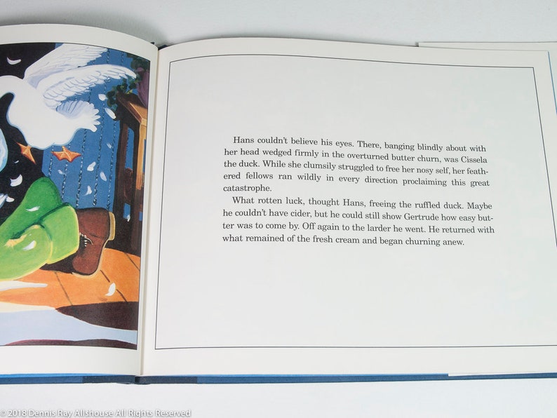May include: An open book with a colorful illustration and text. The illustration depicts a white swan, green objects, and a wooden floor. The text describes a duck stuck in a butter churn and the events that follow.