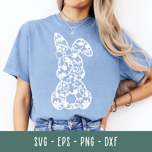 Könnte beinhalten: Ein hellblaues T-Shirt mit einem weißen floralen Hasendesign. Der Hase besteht aus komplizierten Blumenmustern und hat eine Schleife auf dem Kopf.