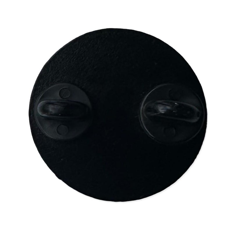May include: Black metal pin back with two metal clasps on the back.
