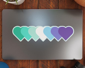 May include: A laptop computer with a sticker of a row of six hearts in shades of green, blue, and purple. The hearts are outlined in a light blue color.