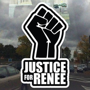 May include: A black and white sticker featuring a raised fist symbol, with the words "JUSTICE FOR RENEE" in bold white letters. The sticker is likely for a social justice cause or protest.