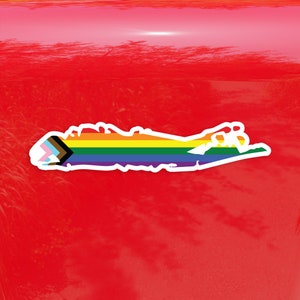 May include: A sticker of Long Island, New York, in the shape of the island with a rainbow pride flag and a progress pride flag.