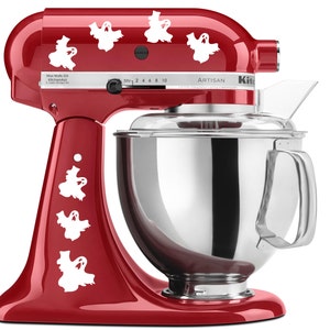 Peut inclure: Un robot pâtissier KitchenAid rouge avec un motif de fantômes blancs. Le robot pâtissier a un bol en verre et une poignée argentée. Le texte "Artisan" est imprimé sur le côté du robot pâtissier.