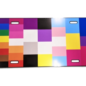 May include: A colorful license plate featuring a patchwork design of squares in various colors, including blue, green, yellow, orange, red, pink, purple, white, and black.