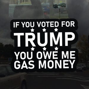 May include: Black and white sticker with the text "IF YOU VOTED FOR TRUMP YOU OWE ME GAS MONEY". The text is in a bold, sans-serif font with star accents. The sticker is likely for a car window.