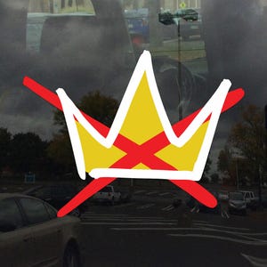 May include: A hand-drawn crown design with a yellow center and a red cross, outlined in white, and crossed out with a red line. The background shows a parking lot with cars and a cloudy sky.