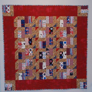 May include: A red, white, and blue patchwork quilt with a geometric pattern. The quilt is made of various fabrics with different patterns, including stars, stripes, and polka dots. The quilt is edged with a red, white, and blue trim.