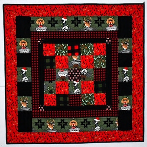 May include: A red, black, and green patchwork quilt with a Christmas theme. The quilt features a variety of holiday-themed images, including reindeer, Santa Claus, and Christmas trees.
