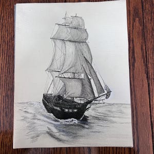 May include: A white ceramic mug with a black handle and the text "But First, Coffee" in a bold, black font. The mug is set against a blurred background, suggesting a cozy setting.