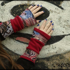 Könnte beinhalten: Rote und gemusterte Fingerhandschuhe mit roter Manschette. Die Handschuhe haben ein geometrisches Muster in Blau-, Braun- und Rottönen. Das Wort "ACCESSORI" ist unten rechts sichtbar.