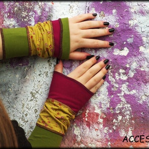 Könnte beinhalten: Ein Paar bunte Fingerlose Handschuhe mit einem Blumenmuster. Die Handschuhe sind aus einem weichen, dehnbaren Stoff gefertigt und perfekt, um jedem Outfit einen Hauch von Stil zu verleihen.