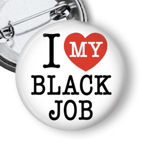 May include: A white button with a red heart and the text "I love my black job".